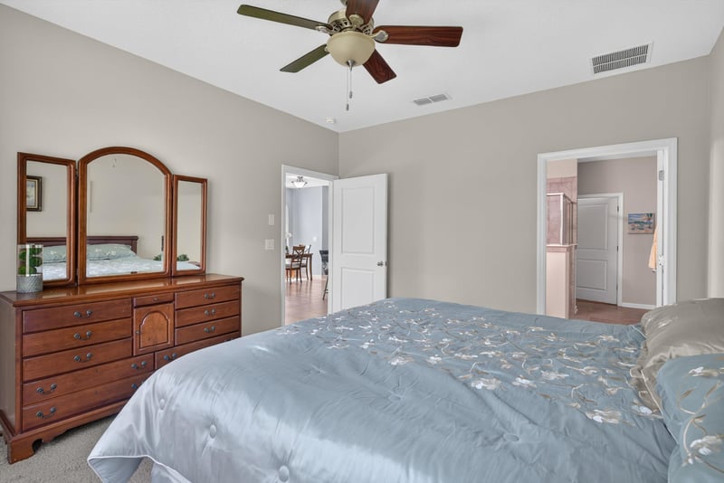 Primary bedroom with dresser and blue bedding at 2378 Caney Oaks Dr, Jacksonville, FL