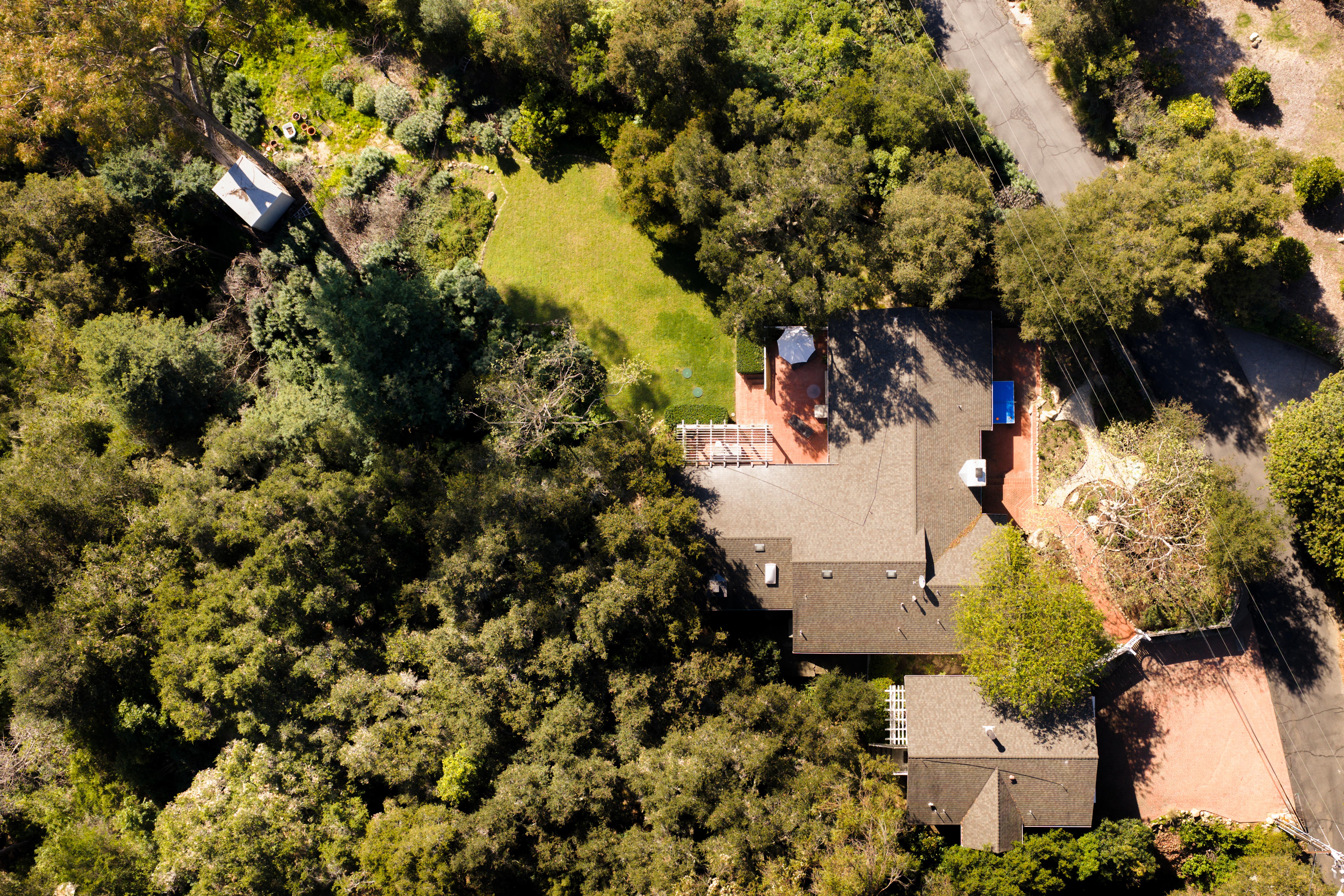 Drone aerial view of Hidden Valley Lane estate, Santa Barbara CA — the Pacific Ocean and Channel Islands emerge on the horizon beyond the roofline in this real estate drone photography image by VirTour Media, serving Montecito, Hope Ranch, and greater Southern California. Our team captured still photography, aerial drone photography, and twilight photography from late afternoon through twilight.