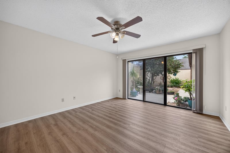 Empty bedroom with ceiling fan and sliding glass door at 3407 Fairbanks Grant Rd N, Jacksonville, FL 32223