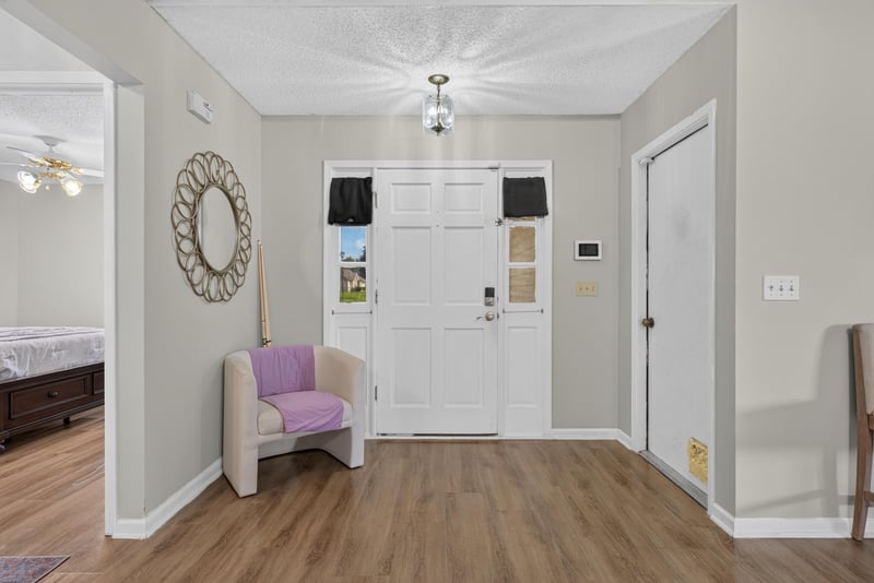 Entry foyer with mirror and front door at 8680 Bandera Cir S, Jacksonville, FL 32244