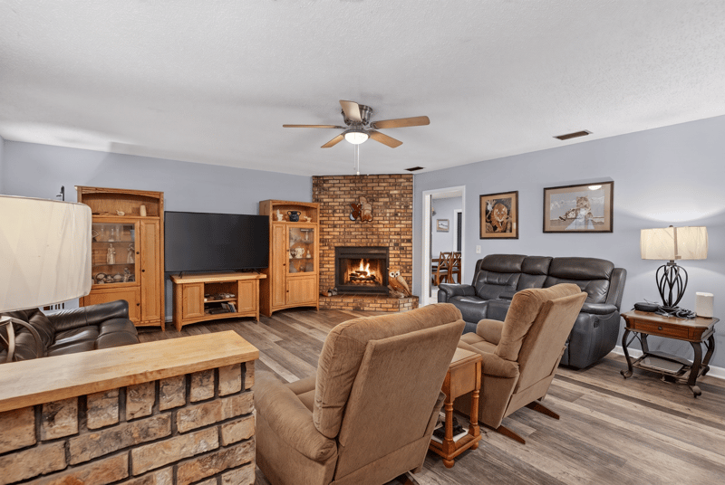 Living room with brick fireplace and wood entertainment center at 3249 Maryland Ave, Green Cove Springs, FL