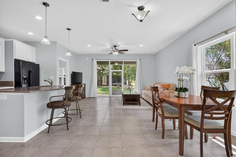 Open kitchen and dining area with ceiling fan and sliding glass door at 2378 Caney Oaks Dr, Jacksonville, FL
