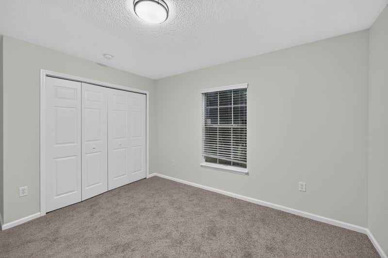 Bedroom closet with sliding doors and carpet at 706 Bonaparte Dr, Jacksonville, FL 32218