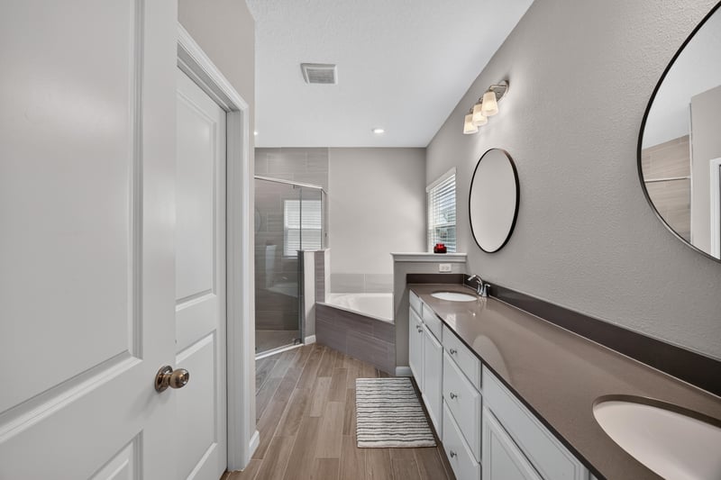 Primary bathroom double vanity with dark countertops at 9942 Lovage Ln, Jacksonville, FL 32219