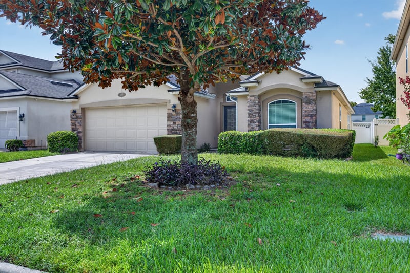 Front exterior with landscaped tree and garage at 469 Glendale Ln, Orange Park, FL