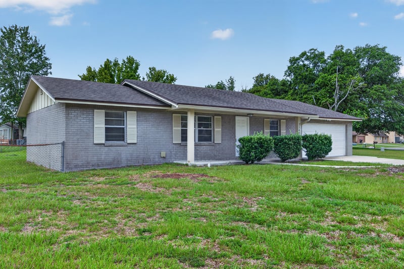 Front exterior closer view with shrubs and garage at 1143 Tumbleweed Dr, Orange Park, FL 32065