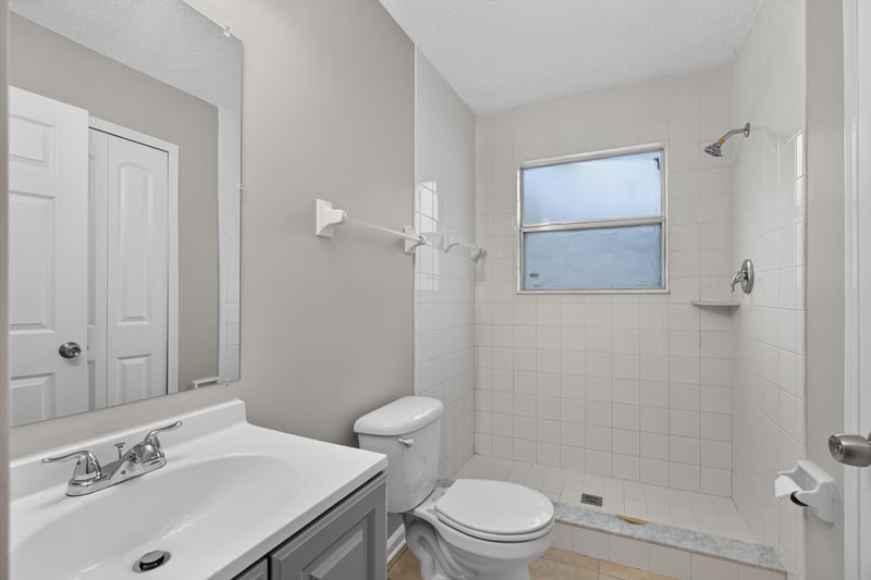 Bathroom with vanity, shower and window at 1040 Willow Cove Ct E, Jacksonville, FL 32233