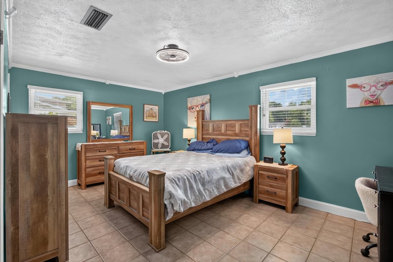 Bedroom with teal walls and wood bed frame at 6059 Karen St, Jacksonville, FL 32244