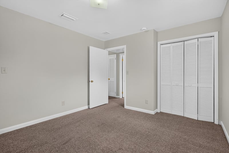 Carpeted bedroom with closets at 2618 Arlex Dr E, Jacksonville, FL