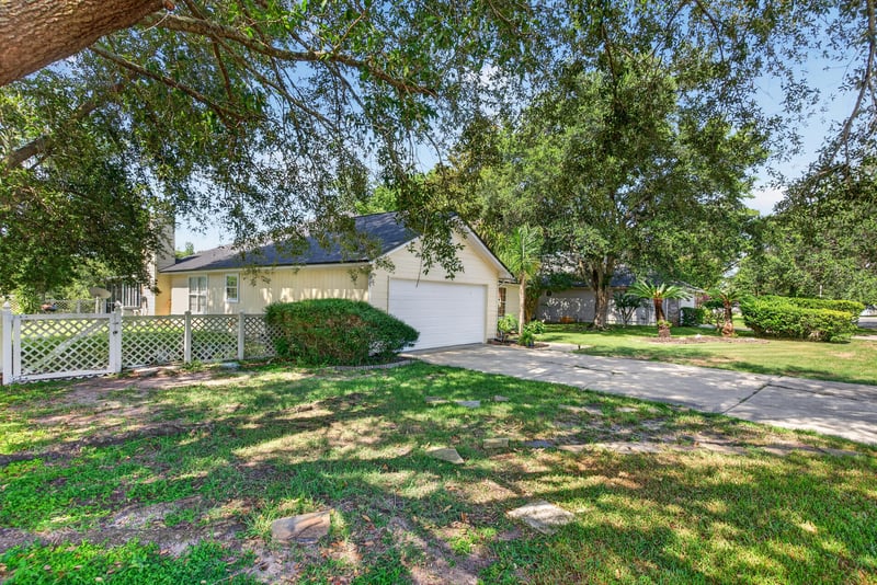Front exterior with driveway and lawn at 8680 Bandera Cir S, Jacksonville, FL 32244