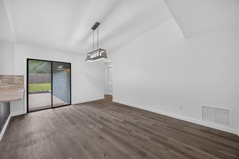 Dining area with vaulted ceiling and sliding glass door at 551 Deltona Blvd, St. Augustine, FL 32086