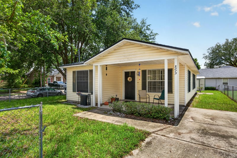 Front exterior with chain-link fence and porch at 5375 Dodge Rd, Jacksonville, FL 32209