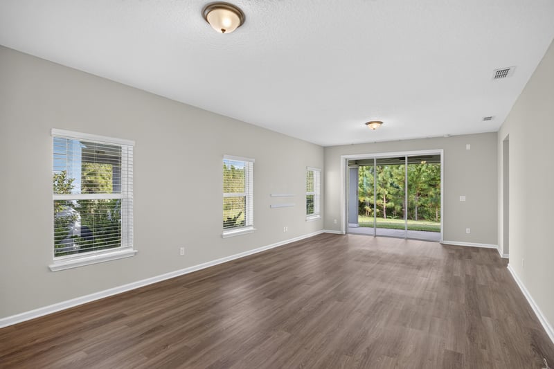 Living and dining area with wood floor and large window at 75875 Saffron Ln, Yulee, FL 32097