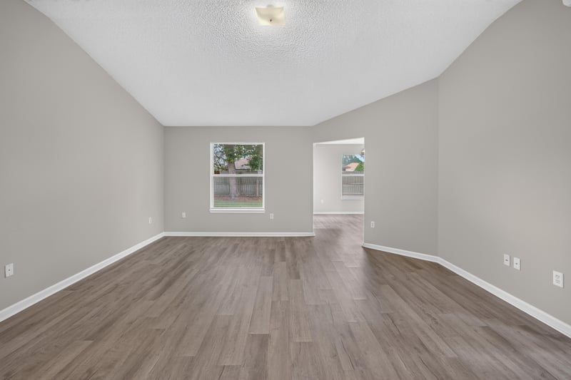 Empty living room with vaulted ceiling, wood floor at 8519 Blazing Star Ct, Jacksonville, FL 32210