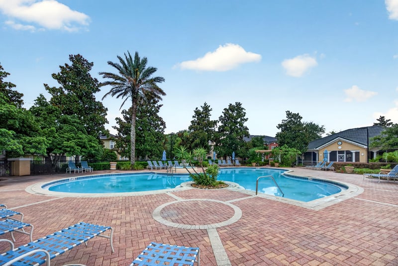 Pool area with pavers and lounge seating in Mirabella Condo
