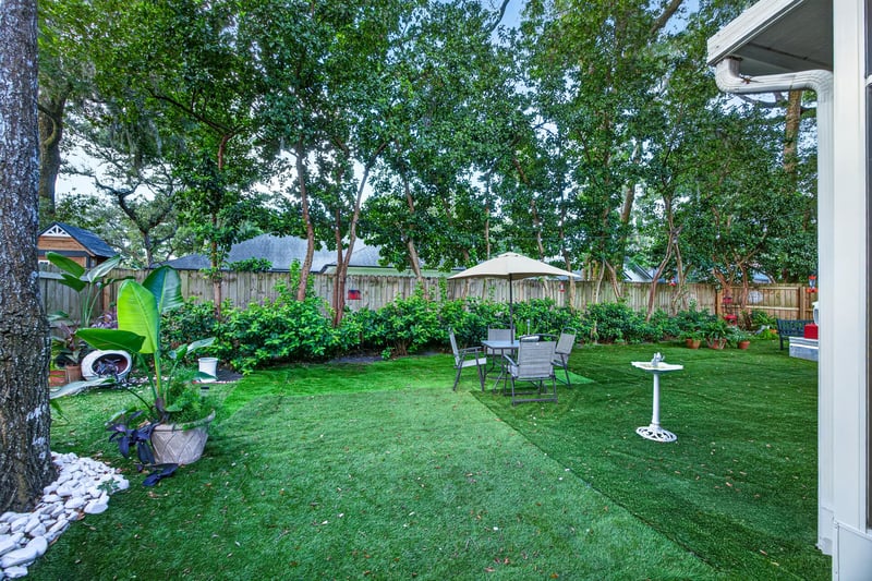 Backyard lawn and seating area with umbrella at 1346 Gately Ct, Jacksonville, FL 32225