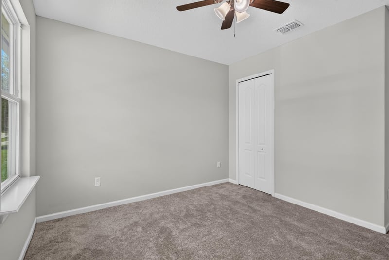 Bedroom corner with ceiling fan and window at 10066 Andean Fox Dr, Jacksonville, FL 32222