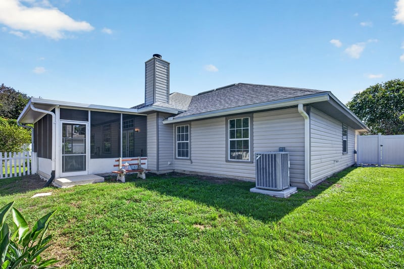 Back exterior with chimney and screened porch at 11828 Heather Grove Ln, Jacksonville, FL
