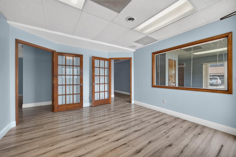 Front room with open French doors and wood-look flooring at 1543 Kingsley Ave #19, Orange Park, FL 32073