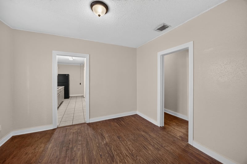 Hallway with wood floors leading toward tile kitchen at 1473 State St W, Jacksonville, FL 32209