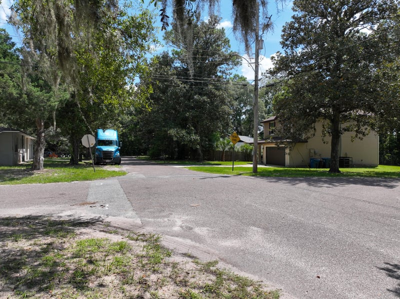 Ground-level view of street with mailbox and trees at 1818 Elm St, Jacksonville, FL 32208