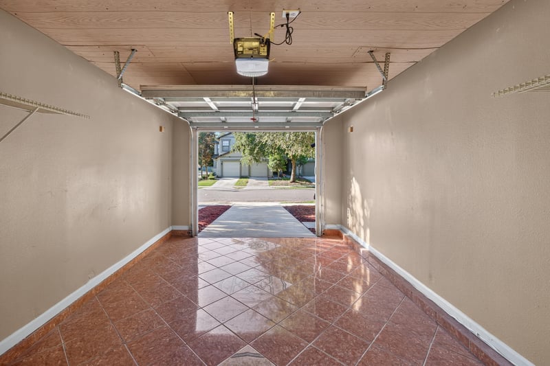 Garage interior with tile flooring and open door at 7723 Playschool Ln, Jacksonville, FL