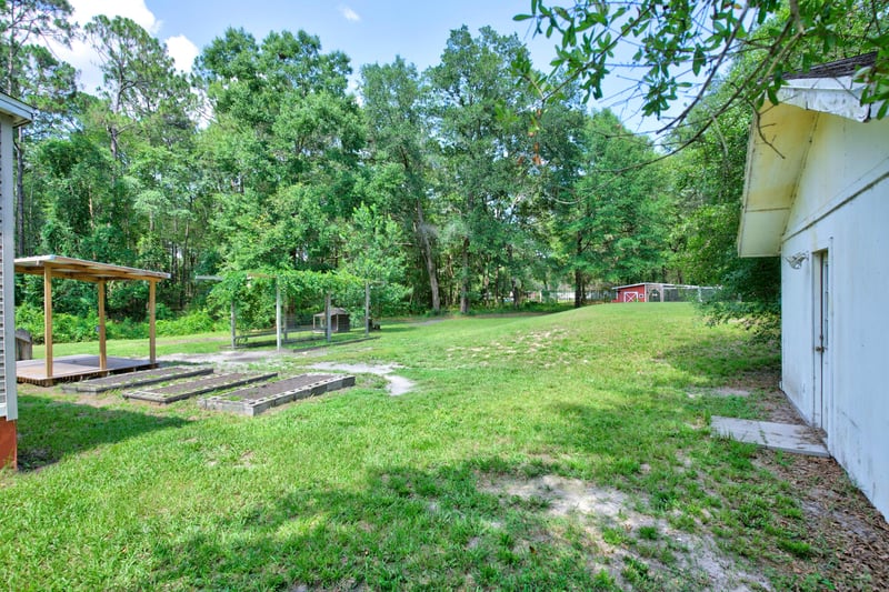Side yard view with pergola and outbuilding at 2549 Snapdragon Ave, Middleburg, FL 32068