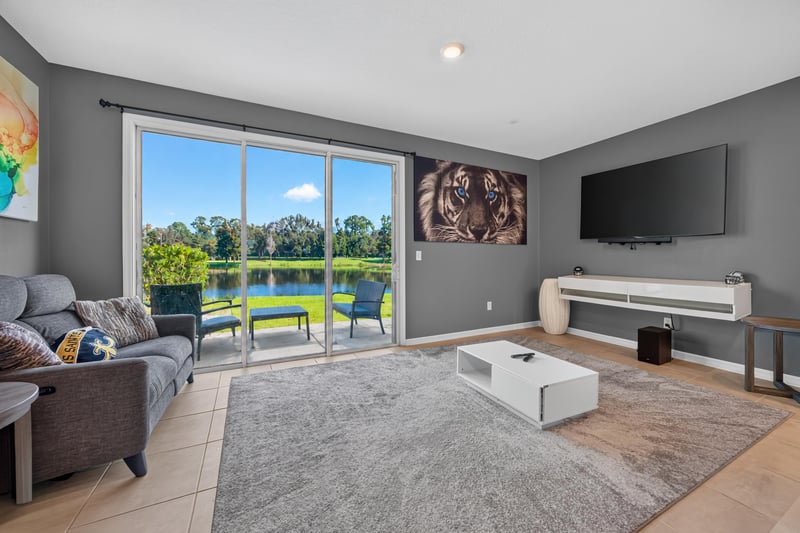 Living room with sectional sofa and sliding glass door to pond view at 339 Anthony Dr, Jacksonville, FL
