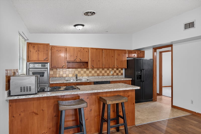 Kitchen with breakfast bar and black appliances at 11462 Elane Dr, Jacksonville, FL