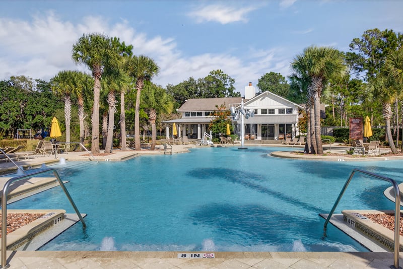 Community pool lined with palm trees in Whisper Creek