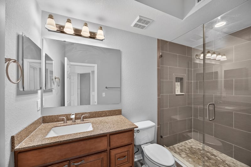 Bathroom with wood vanity and walk-in shower at 10075 Gate Pkwy unit 1905, Jacksonville, FL 32246