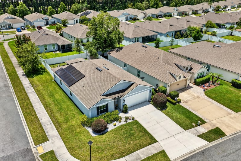Aerial view of the home and solar panels among neighboring houses in Jacksonville, FL