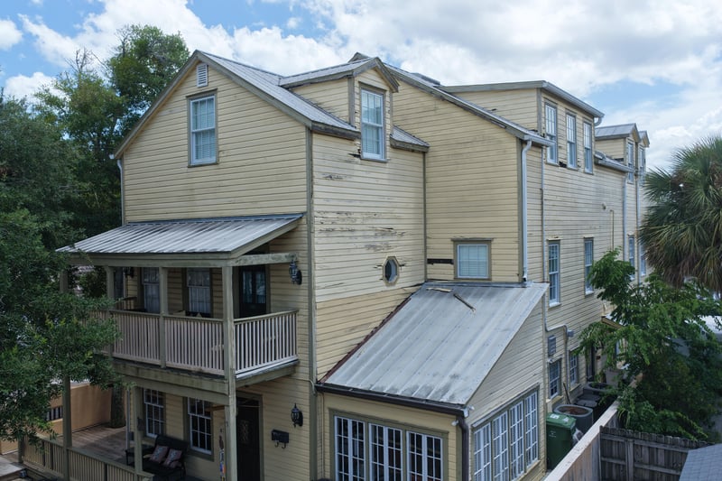 Yellow two-story building with wraparound balconies and metal roof at 29 Cuna St, St. Augustine, FL 32084