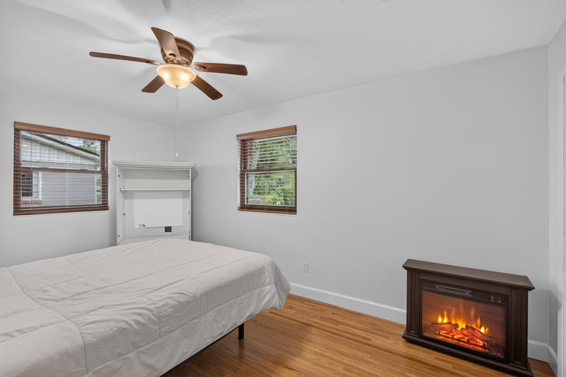 Bedroom with electric fireplace heater and hardwood floor at 1847 Grove Park Dr, Orange Park, FL
