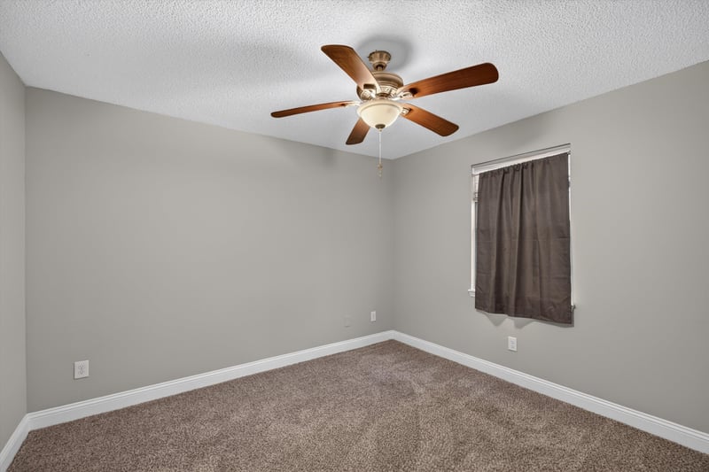 Carpeted bedroom corner with window at 12344 Cormorant Ct, Jacksonville, FL
