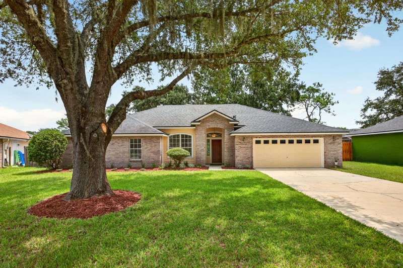 Front exterior view with oak tree and manicured lawn at 456 Bay Point Way N, Jacksonville, FL 32259