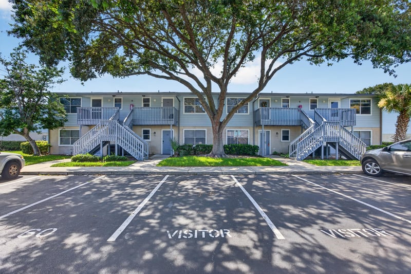Front exterior view with trees and parking lot at 700 W Pope Rd unit h61, St. Augustine, FL 32080