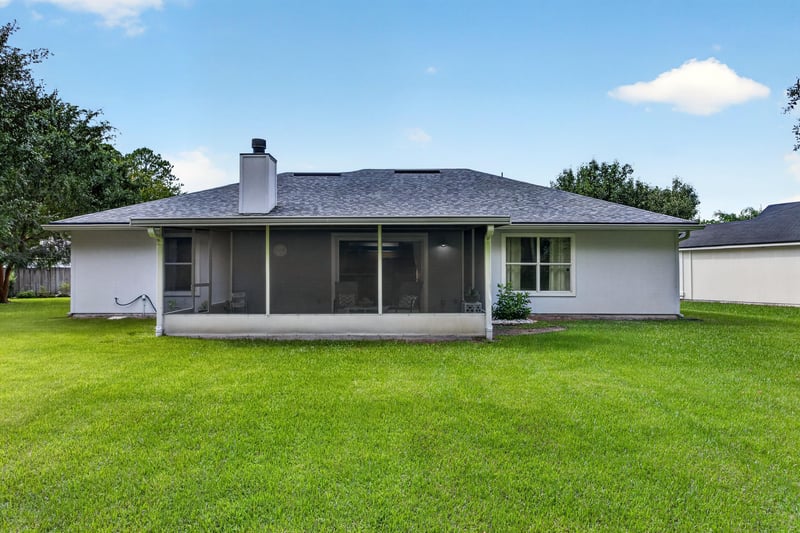 Backyard with screened porch and open lawn at 13514 Las Brisas Way N, Jacksonville, FL