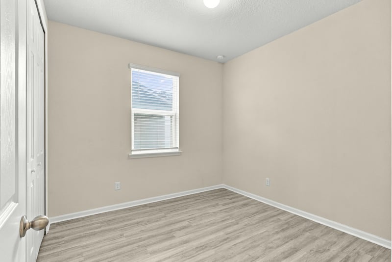 Staged bedroom with upholstered headboard at 7088 Mahogany Run Dr, Jacksonville, FL 32244