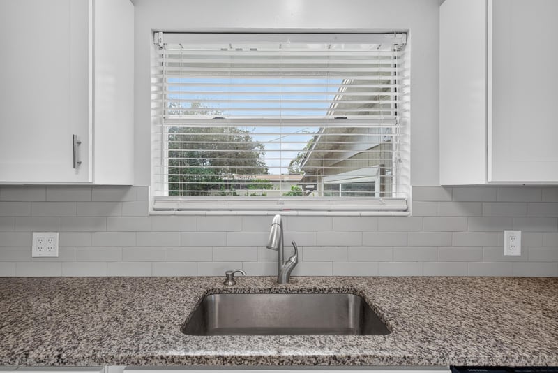 Kitchen sink with granite counter and window view at 217 Baisden Rd, Jacksonville, FL 32218