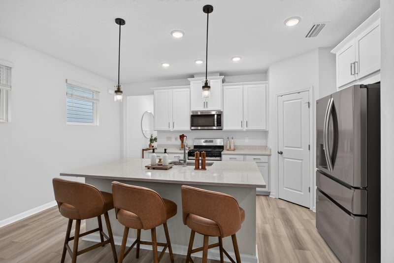 Kitchen island seating and stainless appliances at 93 Lochloosa Ct, St. Johns, FL 32259