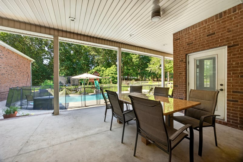 Covered patio with table, chairs, and pool view at 1735 Hagans Ridge Ct