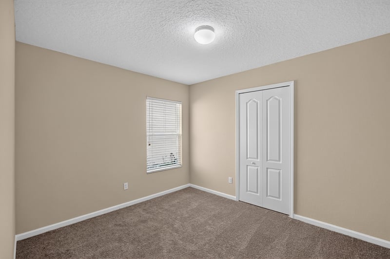 Carpeted bedroom with window and closet at 469 Glendale Ln, Orange Park, FL