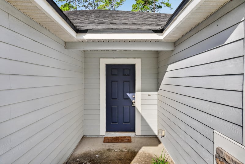 Covered front entry with navy front door at 95221 Siena Ct, Fernandina Beach, FL 32034