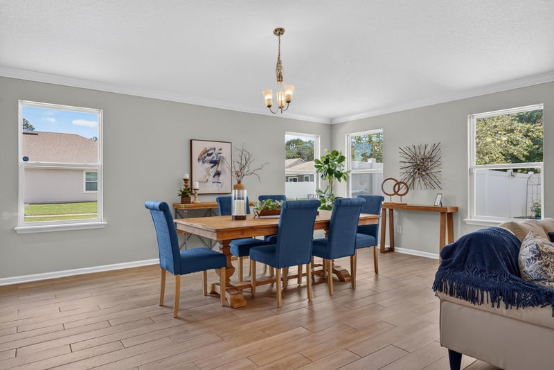 Dining area with blue upholstered chairs and chandelier at 10066 Andean Fox Dr, Jacksonville, FL 32222