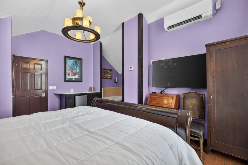 Bedroom with a wood armoire and wall-mounted TV at 115 Cordova St, St. Augustine, FL