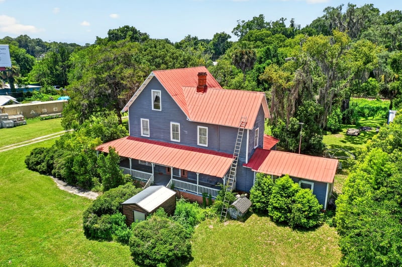 Aerial view of the two-story farmhouse and chimney at 1173 US-17, Satsuma, FL 32189