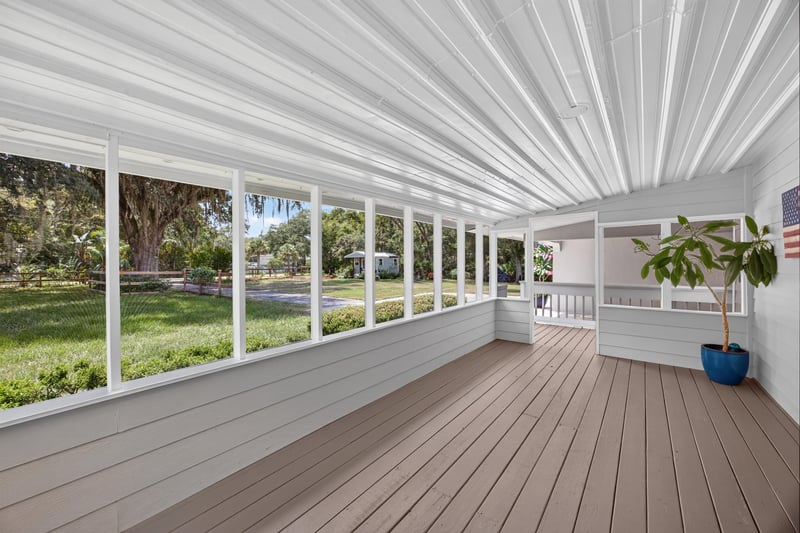 Screened porch with row of windows and wood deck at 1161 Whispering Pines Rd, Jacksonville, FL 32259