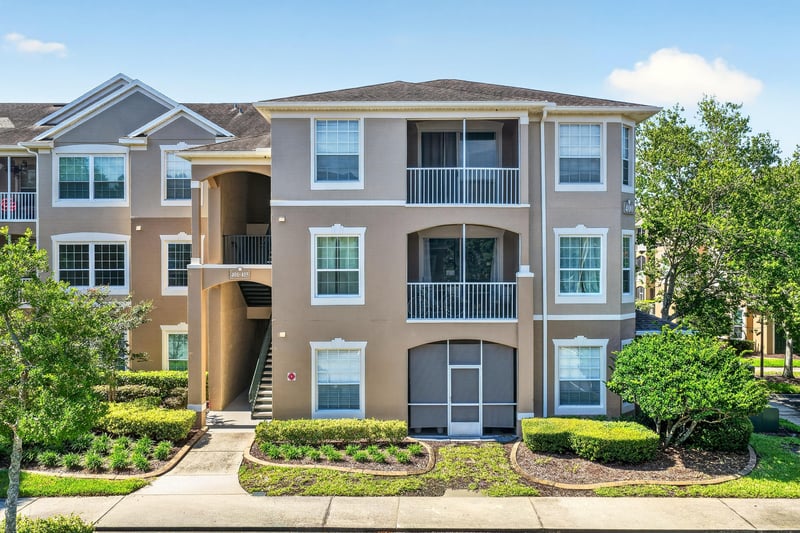 Aerial view of three-story condo building with ponds in Jacksonville