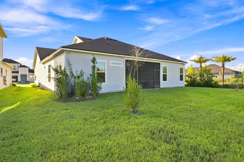 Rear exterior at day-to-dusk with screened patio and open yard at 27 Holly Rdg Wy, St. Augustine, FL